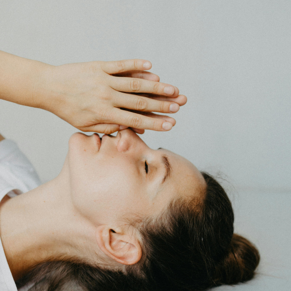 Naine lebab ja toetab käed laubale – meditatsiooniline hetk
